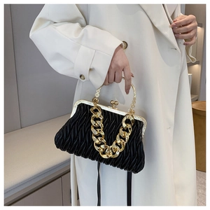 Detail of black pleated shell bag with wave quilting and chunky gold chain strap