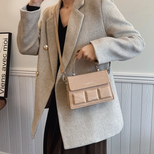 Beige chocolate-textured crossbody box bag shown on model in minimal aesthetic style