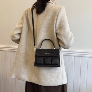 Minimalist black embossed patent leather box bag with adjustable crossbody strap