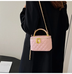 Vue détaillée du sac à bandoulière matelassé rose avec chaîne dorée porté par un mannequin