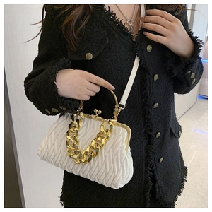 Detailed view of white pleated matelassé leather bag with vintage gold chain strap