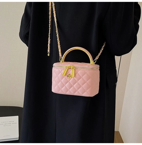 Détail du sac en cuir rose matelassé avec zip fleur doré et poignée en métal