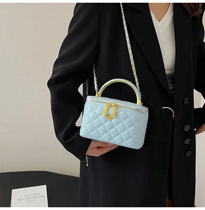 Détail du mini sac matelassé bleu clair avec zip floral doré et poignée métallique