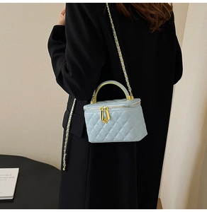 Détail du mini sac matelassé bleu clair avec chaîne dorée et poignée en métal