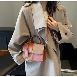 Détail d'un sac bandoulière en cuir marron et tweed avec une étiquette de mode