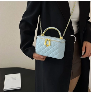 Détail du mini sac matelassé bleu clair avec breloque fleur dorée et bandoulière