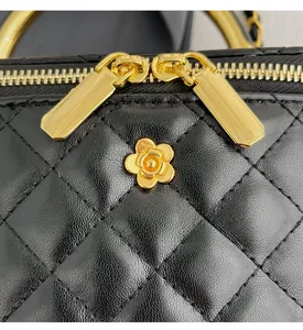 Détail macro du cuir matelassé et de la fleur de camélia dorée sur le sac noir élégant