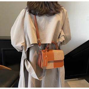 Vue détaillée d'un petit sac à bandoulière marron en similicuir porté par un mannequin