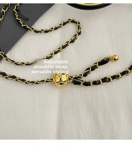 Détail de la bandoulière chaîne réglable en métal doré et cuir noir avec perle matelassée