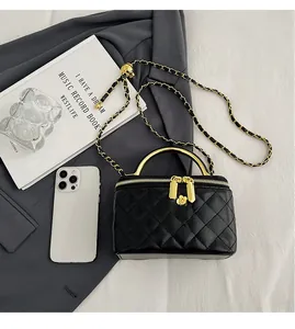 Détails du mini sac matelassé noir avec chaîne dorée et breloque florale sur le zip