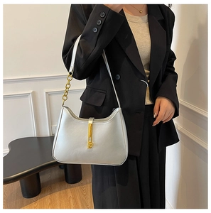 Detail of silver hobo bag featuring gold piston clasp and metal chain strap accent