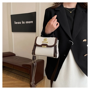 Détail d'un sac à main en cuir blanc avec large bandoulière porté par un mannequin chic