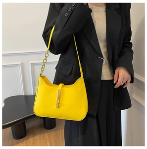 Detailed close-up of a bright yellow leather hobo bag with a gold metal piston clasp