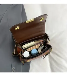 Vue détaillée de l'intérieur spacieux d'un sac bandoulière en cuir marron pour maquillage