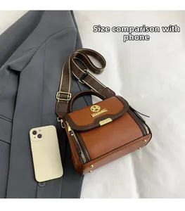 Vue détaillée du sac à main marron à motif litchi montrant la taille par rapport au téléphone