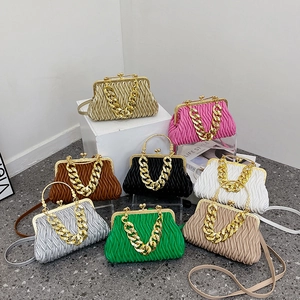 Pleated shell bag with gold chain strap in eight candy colors on a modern display