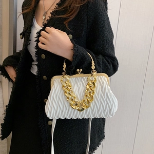 White matelassé shell handbag with chunky gold chain and vintage metal frame clasp