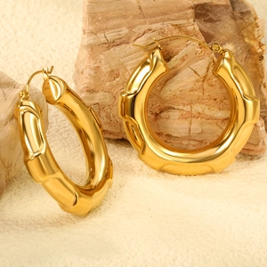 Polished gold bamboo hoop earrings with minimalist chunky metal texture and pin clasp