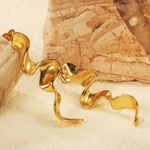Minimalist gold wavy stud earrings featuring a fluid curved design on a textured stone base