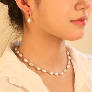 Elegante 18K vergulde roestvrijstalen ketting met zoetwaterparels gedragen door een model