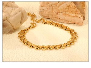 Detailansicht eines vergoldeten Edelstahl-Armbands mit blattförmigen Gliedern und Karabiner