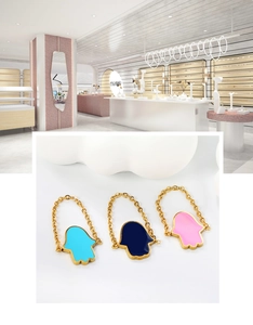 Detailed close-up of Hamsa hand soft chain rings in sky blue, navy, and pink enamel