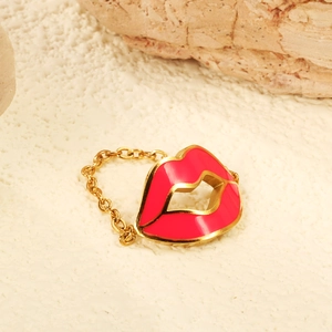Creative gold chain ring featuring a red lip-shaped enamel design on a stone background