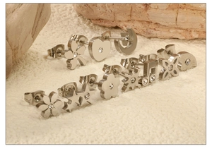 Détail macro de divers clous d'oreilles en acier inoxydable avec cristaux sur pierre