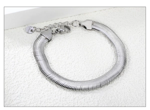 Detailed close-up of silver stainless steel flat snake chain with lobster clasp and tag