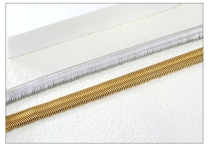 Macro detail of high-polished gold and silver flat snake chain texture in stainless steel