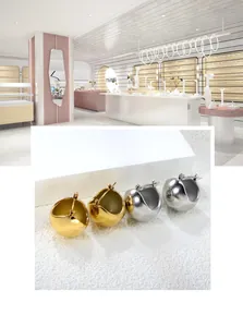 Vue détaillée des boucles d'oreilles boules creuses en finitions or et argent polies
