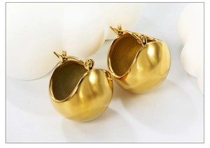 Gros plan sur des boucles d'oreilles goutte dorées 18 carats avec finition miroir polie