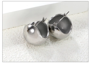 Gros plan de boucles d'oreilles sphériques creuses argentées avec finition miroir poli