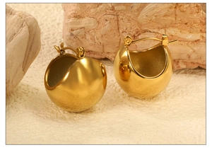 Vue macro de boucles d'oreilles créoles bombées plaquées or 18 carats avec fini miroir