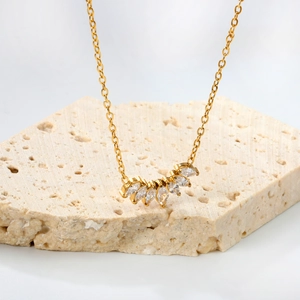 Elegant gold diamond necklace with fan-shaped marquise zircon pendant on white stone base
