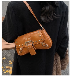Gros plan du sac à bandoulière marron style punk avec clous et boucles en métal