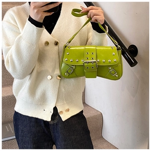 Détail du sac à bandoulière en cuir verni vert fluo avec clous argentés punk et boucles métal