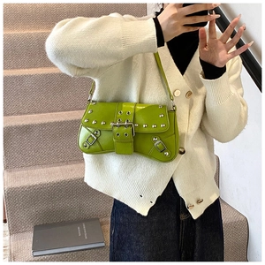 Gros plan du sac à bandoulière vert vif avec clous argentés punk et boucles métalliques chic