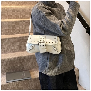 Détail du sac à épaule blanc avec rivets argentés et boucle en métal design