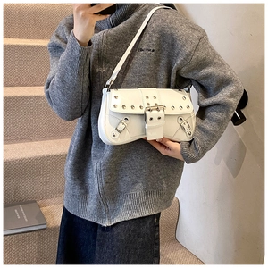 Détail du sac à bandoulière en cuir blanc avec clous en métal et boucles décoratives