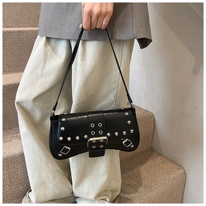 Détails des rivets argentés et de la boucle sur le sac baguette noir style punk