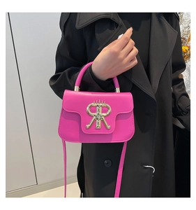 Close-up of fuchsia square handbag with gold RR logo buckle and slim shoulder strap
