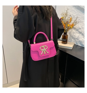 Detail of hot pink crossbody bag with a large gold RR metal buckle and crown logo