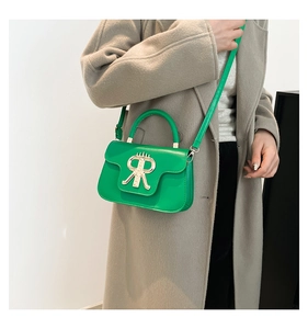 Model wearing bright green leather handbag with gold metal RR logo and shoulder strap