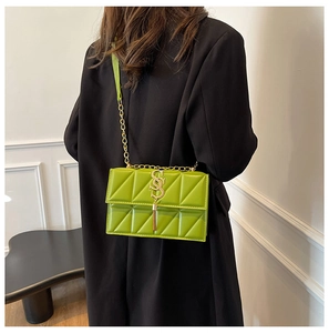Detail of lime green crossbody bag with geometric quilting and gold tassel buckle charm