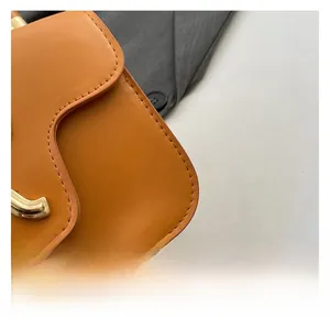 Macro view of ginger yellow leather texture and polished gold metal buckle with fine stitching