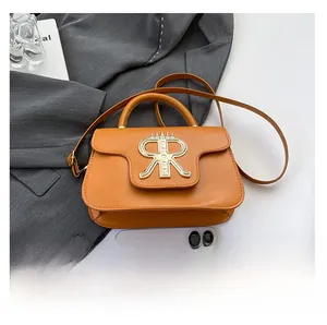 Detail view of orange-brown leather mini bag with golden crown RR logo and thin strap