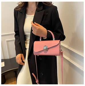 Detail of pink glossy patent leather handbag with silver sphere buckle and metal feet