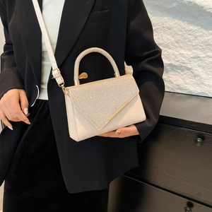 Elegant beige square handbag with sparkling crystal handle and adjustable strap