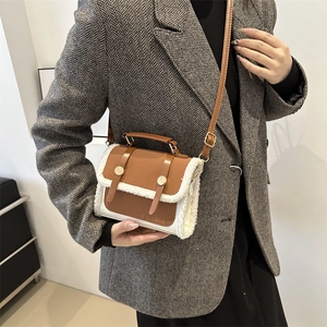 Vintage brown leather crossbody bag with plush white trim worn on a grey blazer